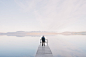 Man Wearing Jacket Standing on Wooden Docks Leading to Body of Water