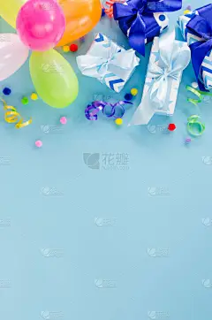 派对或生日蓝色背景。假日恶作剧。有复制空间的贺卡。框架与彩色气球，礼品盒和蛇形。顶部视图。平躺在床上