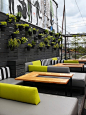 Casual Rooftop Terrace -Bright yellow pops against sedate black, white and grey cushions.  A graphic, abstract mural by Balint Zsako and a wall of hanging garden pots contrast the clean-lined loungers of the Drake Hotel's Sky Yard bar.