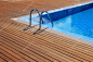 蓝色游泳池与柚木实木地板的条纹的暑假