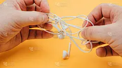 黄色背景下，男子解开耳机。近距离