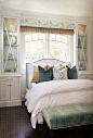 Another good example of how to perch a bed in a window, with attractive cabinets on either side. Layered window treatment.: