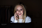 Woman at night holding smartphone, making phone call.