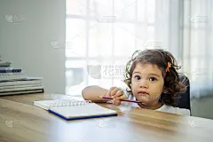 可爱的小女孩坐在家里的书桌前做作业、读书、写字、画画。儿童漆。孩子们画。家里有书的学龄前儿童。学龄前