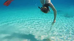 女士浮潜，在蓝色海洋的水下游泳
