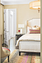 Cream Guest Bedroom Vignette with Large Pendant : Nailheads reappear in a guest room on a bed by Vanguard Furniture, enlivened by a colorful accent pillow and hand-tufted rug, both by Missoni. A Chamber side table from Century Furniture is topped with a m