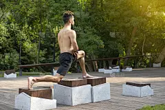 一个在城市公园练习普拉提的好动的男人。