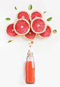 Grapefruit juice in bottle with thinking bubbles formed by slice of grapefruit.