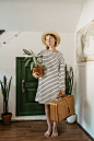 Woman Carrying Pot of Green Plant