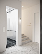 Cisne Lounge Café Design 8 - Brightly lit white hallway with gray floor covering that provides access to the elevator and staircase, following with the minimal ambience that is applied throughout the lounge café design, by Comelite Architecture, Structure