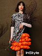 Stacy Martin poses in printed blouse with orange ruffled skirt