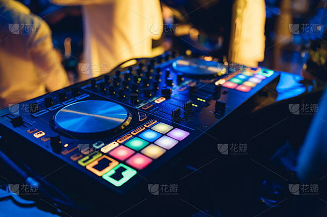 专业的DJ在海滩夜总会的舞台上，在转盘上演奏现场的布景和混音音乐。在俱乐部派对的混音台播放Jokey