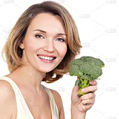 漂亮年轻健康的女人抱着花椰菜。