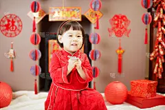 中国女婴的传统装扮庆祝中国新年，反对各种“FU”意为“幸运”的装饰和贺卡背景