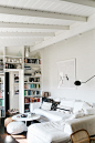 white washed living room with pops of color on bookshelf. / sfgirlbybay