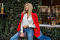 Free photo young european  confident woman with   candid smile posing outdoor in the bar. wearing red fashionable jacket