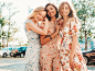 Free photo three beautiful smiling girls in trendy summer sundress posing on the street