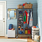 organized entryway with a rolling coat rack closet and baskets | 100+ Beautiful Mudrooms and Entryways at Remodelaholic.com