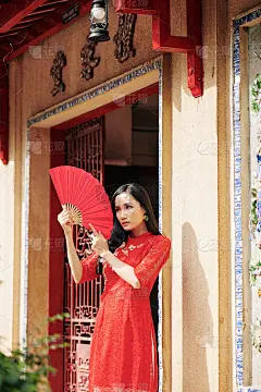 亚洲妇女与纸扇摆姿势