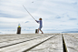 Boy fishing off lakeside dock by Caia Images on 500px
