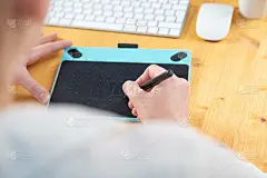 特写女性的手使用数字图形平板电脑和手写笔，而在现代办公室工作