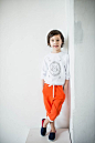 Photo of Child Leaning on Wall With Feet Crossed