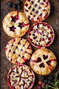 Six blackberry tarts with various designs