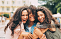 Girlfriends in the city Three best friends hugging each other in the city. Women Stock Photo