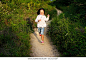 Happy little girl running down a winding path in the countryside at sunset