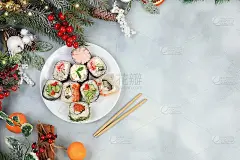 新鲜的人行横道寿司卷配上酱汁，灯光背景上有节日装饰，圣诞新年食物，传统日本料理，
