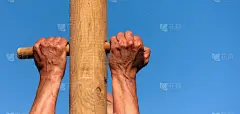 一个男人爬上一根柱子