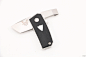 BM 602 Tengu Tool : This Tengu Tool friction folder designed by Jared Oeser, produced by Benchmade features a CPM20CV tanto blade shape with pry and bottle opener at the tail. Handle has black G10 scales with white liners and escutcheon. Marked First Prod