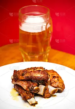 白盘子里的烤排骨和啤酒
