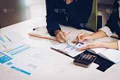 商业女性和合作伙伴指着财务图表计划预算和成本。企业财务分析和战略概念。