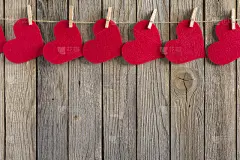 红心和衣夹挂在一根绳子上的旧木制背景上