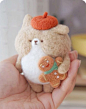 This may contain: a hand holding a small stuffed animal with an orange hat on
