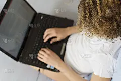 俯视图女孩在床上用笔记本打字