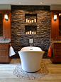 Example of a trendy pebble tile floor freestanding bathtub design in Cedar Rapids with flat-panel cabinets and dark wood cabinets