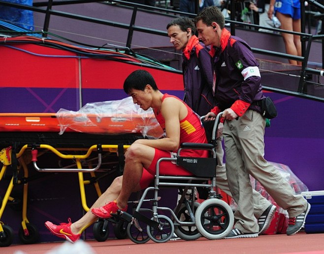 刘翔在志愿者的担架帮助下离开赛场