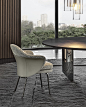 Angie Dining Chair by Minotti —  | ECC : A saddle hide element designs a wing that embraces the armchair, sustaining the frame like a sculptural bustier, characterised inside by the inviting softness of the seat and backrest. Behind the apparent simplicit