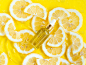 玻璃精油，血清瓶在夏季背景与黄色柠檬片在水中有波纹