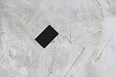 黑色模拟名片在灰色纹理水泥粗糙表面，混凝土墙为背景。水平的。对于文本和设计