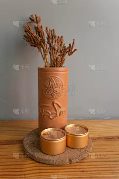 瓷瓶里的干花摆放在木桌和灰色的墙上。