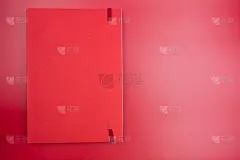 在红色的背景上关闭红色的纸笔记本