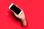 Hand with smartphone on red