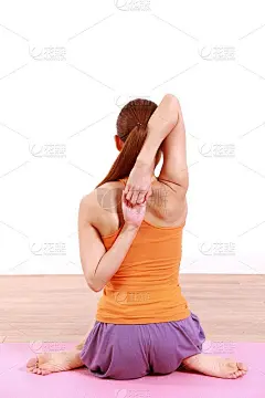 年轻女子做瑜伽“牛脸姿势”