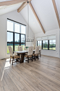 Huge farmhouse vinyl floor, brown floor and exposed beam kitchen/dining room combo photo in Portland with white walls, a standard fireplace and a plaster fireplace