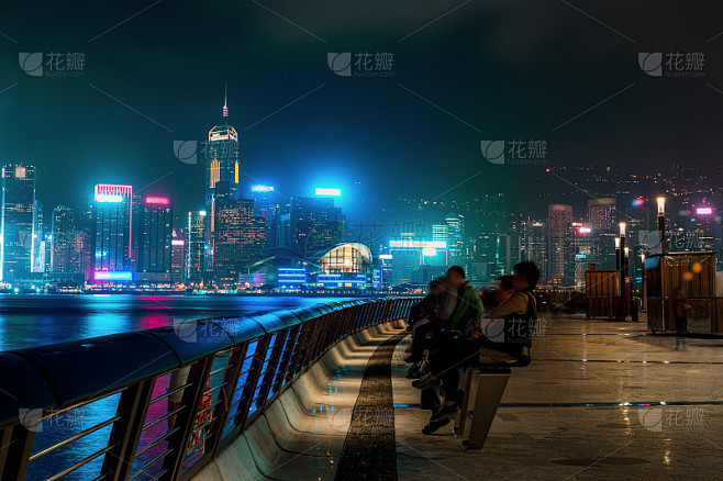 香港城市夜景。在海滨散步的游客
