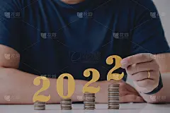 男子手持2022号，白色桌上有硬币。新年存钱理财理念。