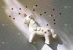 闪亮的白色背景上有星星的小独角兽。魔术的概念，童年的梦想，现代的趋势为广告的普遍。
